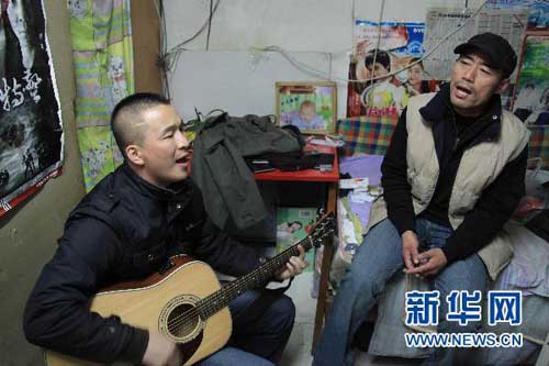  11月11日，王旭（右）和刘刚在刘刚租住的房屋内唱歌。连日来，北京两位农民工歌手在出租屋内即兴自拍的歌曲视频《春天里》，在互联网上得到数以千万计点击和转载，让网友“哭得无法抑制”。新华社记者 邢广利 摄