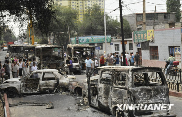 7月6日，乌鲁木齐市北湾街上停放着多辆被烧毁汽车。